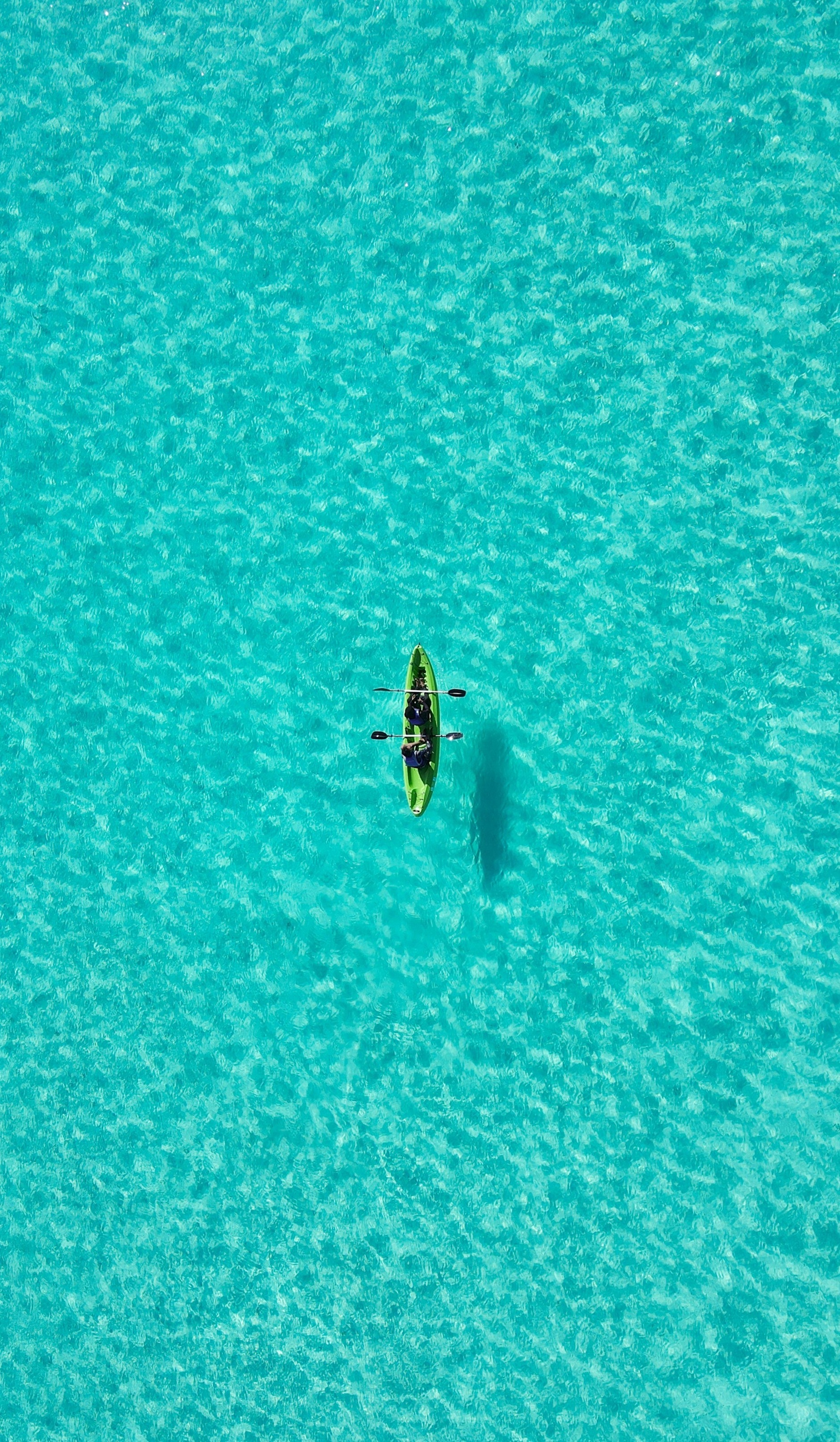 People kayaking in the Maldives' turquoise waters.