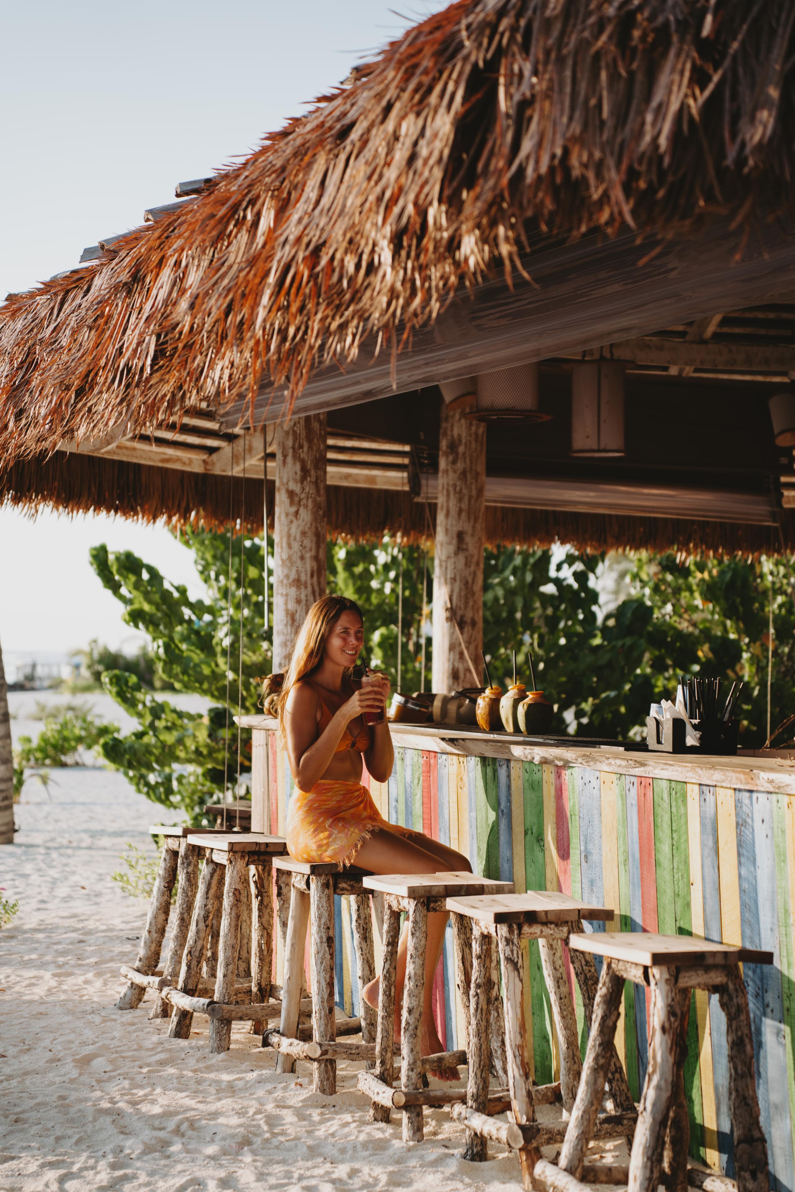 Woman at a poolside bar in the Maldives' tropical setting.